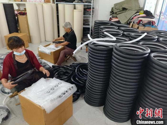 圖為村民在汽車飾品企業(yè)生產(chǎn)車間中工作?！巫雍?攝