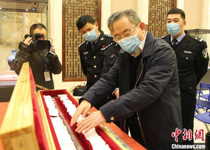 山東博物館館長(zhǎng)鄭同修介紹涉案文物龍首錯(cuò)銀木柲銅杖?！≮w曉 攝