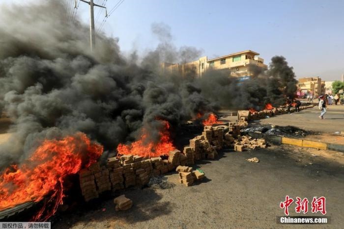當(dāng)?shù)貢r間10月25日，蘇丹局勢發(fā)生突變，過渡政府總理被“綁架”，政府部長被軍方抓捕，國家進入緊急狀態(tài)，大量民眾走上街頭對軍方行動進行抗議，已有7人在抗議活動中死亡，140人受傷。圖為抗議活動中燃燒的輪胎。
