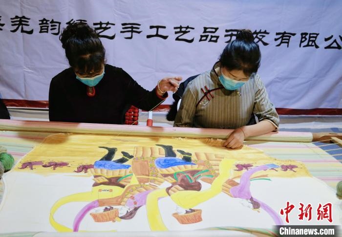 圖為皮繡藝人在市集上“秀”指尖技藝?！●R銘言 攝