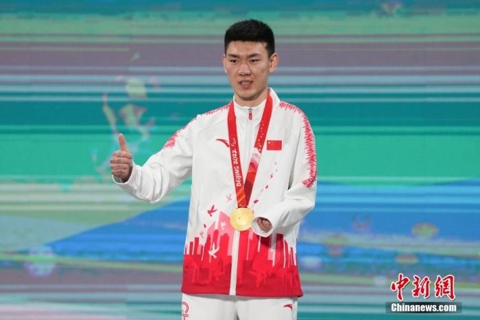 3月6日，梁景怡在延慶頒獎廣場領(lǐng)獎臺上豎起大拇指。當(dāng)日，在國家高山滑雪中心舉行的北京2022年冬殘奧會殘奧高山滑雪男子超級大回轉(zhuǎn)—站姿決賽中，中國選手梁景怡奪得冠軍。 <a target='_blank' href='/'>中新社</a>記者 楊華峰 攝