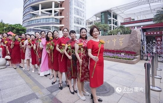6月7日一早，廈門雙十中學考生家長們身穿旗袍，手拿向日葵在考場外為孩子加油打氣，寓意“旗開得勝，一舉奪魁”。人民網(wǎng)記者 陳博攝