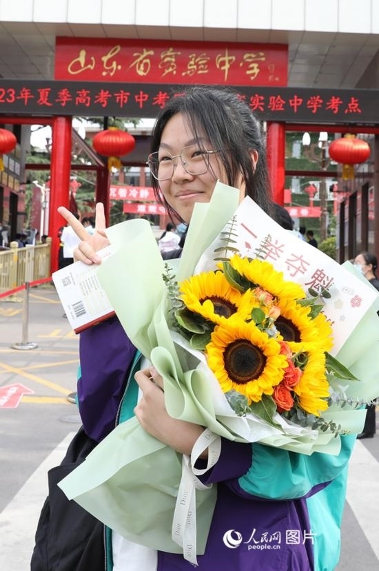 6月7日高考首日，山東67萬考生走進考場，拼搏逐夢。在山東省實驗中學考點，考生進考場前手捧向日葵花拍照留念，寓意“一舉奪魁”。人民網(wǎng)記者 劉祺攝