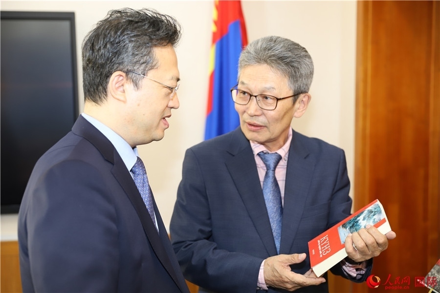 其米德策耶（右一）向李峙介紹翻譯成果。人民網(wǎng)記者 霍文攝