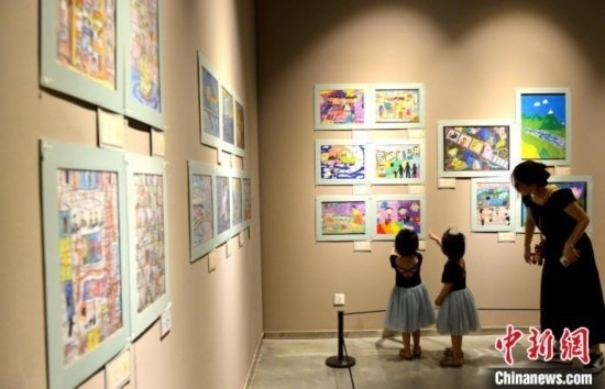 圖為家長(zhǎng)帶著孩子參觀展覽。呂明 攝