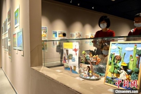 圖為家長(zhǎng)帶著孩子參觀展覽。呂明 攝