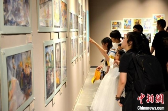 圖為家長(zhǎng)帶著孩子參觀展覽。呂明 攝