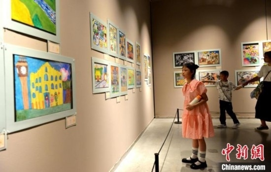 圖為家長(zhǎng)帶著孩子參觀展覽。呂明 攝