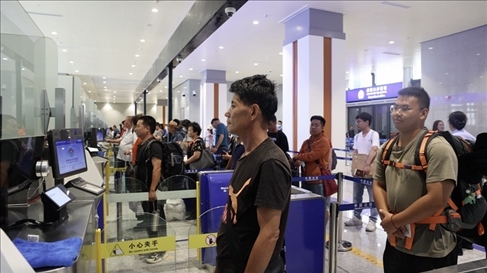 6月13日，乘坐中老鐵路國(guó)際旅客列車的旅客在磨憨邊檢大廳排隊(duì)候檢。李揚(yáng) 攝