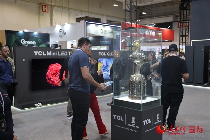 參觀者在TCL展臺(tái)前觀看南美解放者杯獎(jiǎng)杯，據(jù)介紹，TCL是南美解放者杯（2023—2026賽季）全球官方合作伙伴。（人民網(wǎng)記者 時(shí)元皓攝）