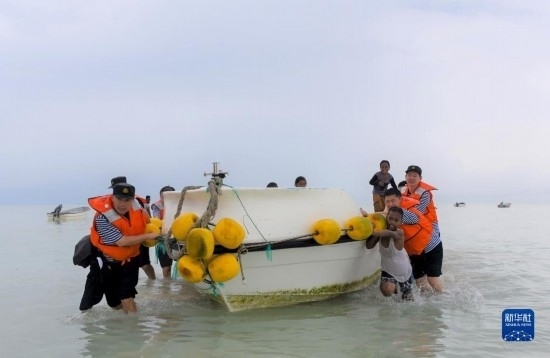 7月21日，中國海軍“和平方舟”號醫(yī)院船醫(yī)護人員涉水登島，前往基里巴斯一診療點。新華社記者 黎云 攝