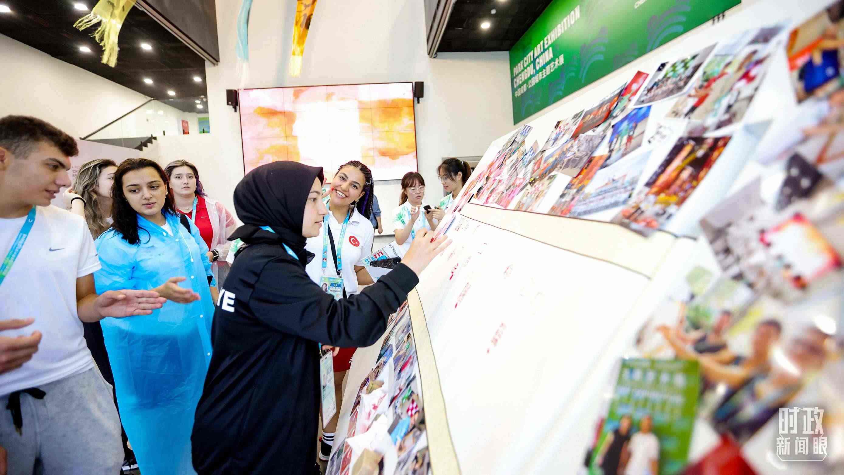 各國青年運動員正在參觀成都大運村內的“雪山下的公園城市，煙火里的幸福成都”主題藝術展。（總臺央視記者魏幫軍拍攝）