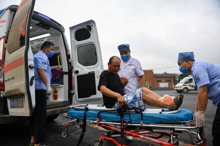 8月1日，在北京市門頭溝區(qū)妙峰山鎮(zhèn)妙峰山民族學(xué)校臨時安置點，北京急救中心工作人員在轉(zhuǎn)運一名受傷村民。新華社記者 鞠煥宗 攝