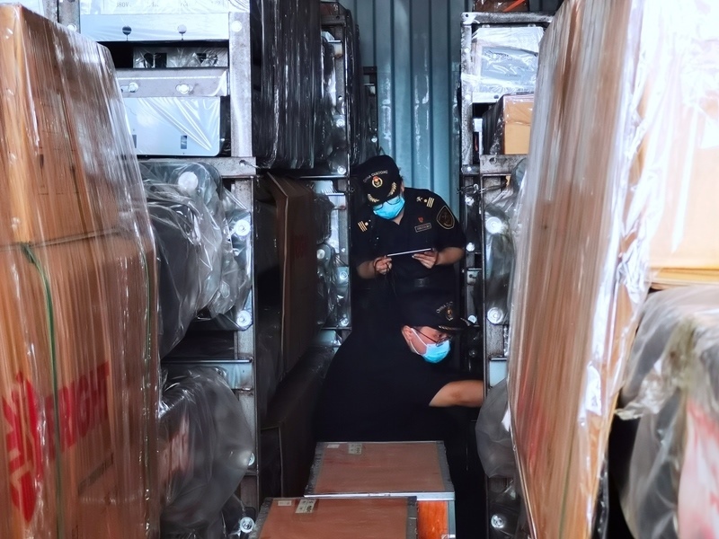 關(guān)員利用工業(yè)內(nèi)窺鏡在集裝箱內(nèi)進行查驗。人民網(wǎng)記者 栗翹楚攝