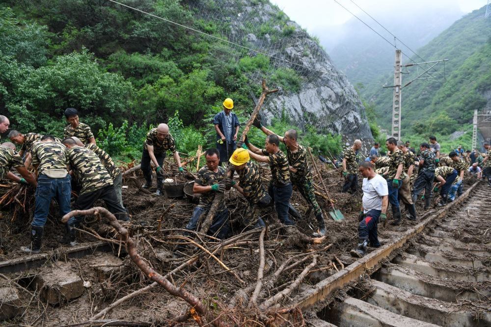 8月1日，在北京市門頭溝區(qū)水峪嘴村附近一段被阻斷的鐵路線上，中鐵六局工作人員在清理軌道上的雜物，全力恢復(fù)交通。新華社記者 鞠煥宗 攝