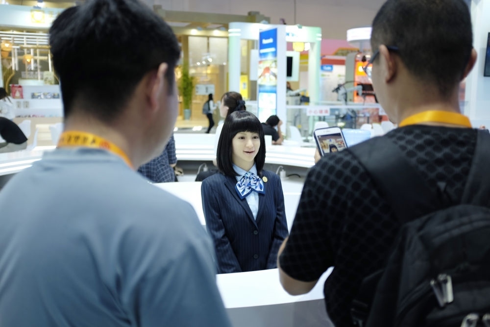 9月1日，媒體記者在國(guó)家會(huì)議中心與服務(wù)機(jī)器人互動(dòng)。新華社記者 劉夢(mèng)琪 攝