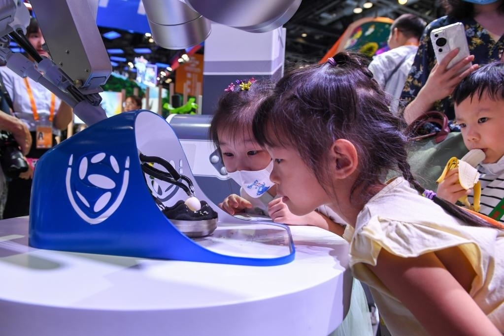 9月3日，幾名小朋友在國家會議中心觀看單孔腔鏡手術(shù)機(jī)器人展示。新華社記者 鞠煥宗 攝