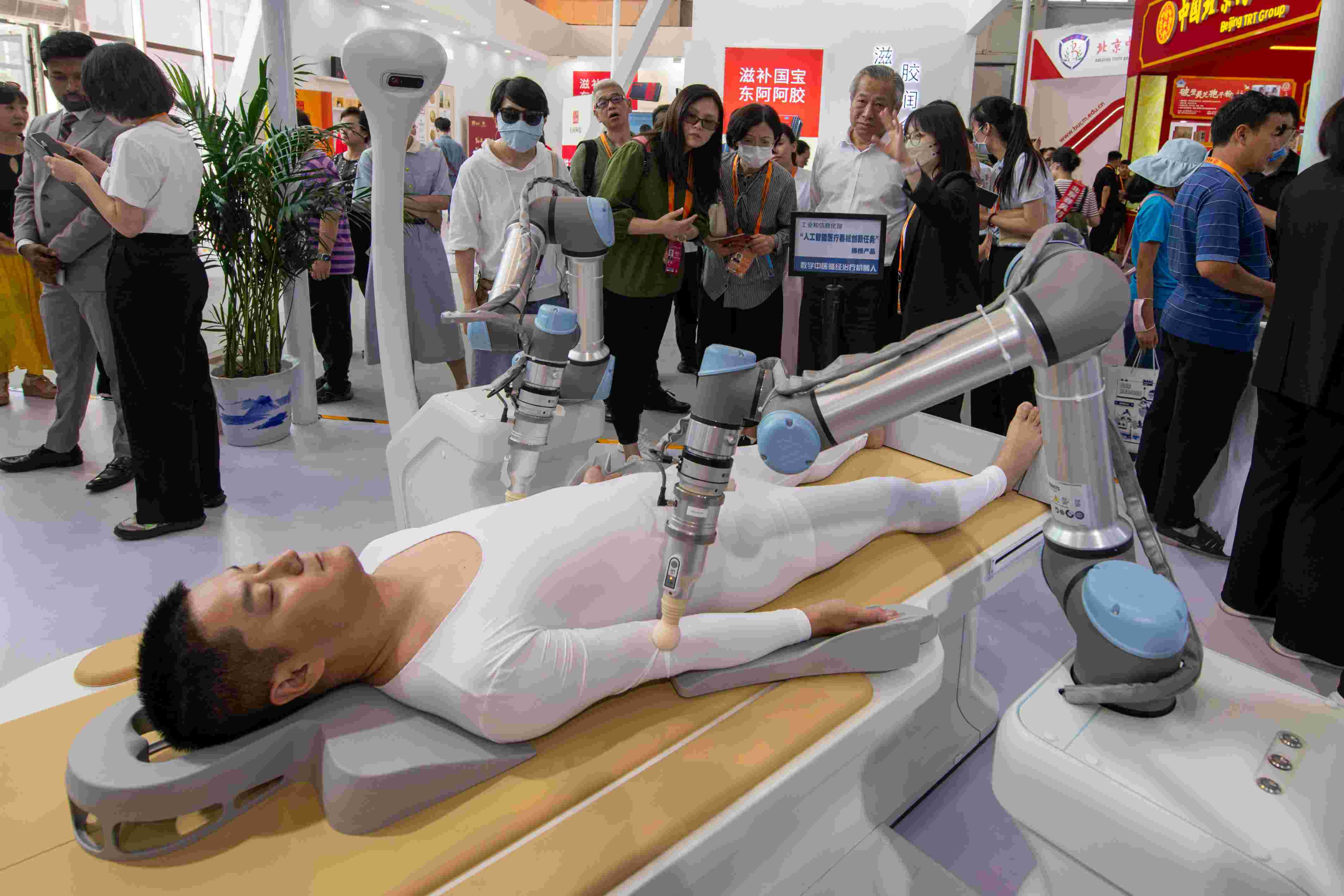 在位于首鋼園的健康衛(wèi)生服務(wù)展區(qū)，觀眾正在參觀數(shù)字中醫(yī)循經(jīng)治療機(jī)器人。人民網(wǎng)記者 翁奇羽攝