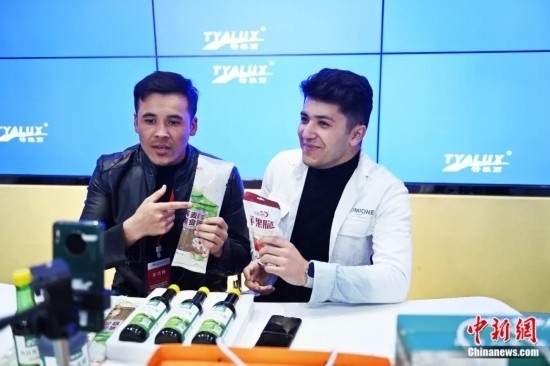 2023年3月，甘肅省慶陽市環(huán)縣電商創(chuàng)業(yè)孵化基地內(nèi)，來自蘭州文理學(xué)院的塔吉克斯坦留學(xué)生正在協(xié)助主播直播帶貨當(dāng)?shù)剞r(nóng)特產(chǎn)品。李亞龍 攝