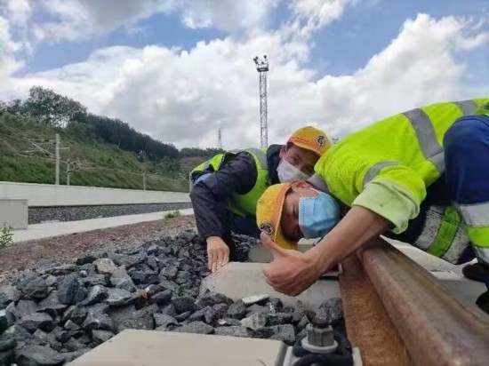 佟郎（左）正在檢修鐵路。受訪者供圖