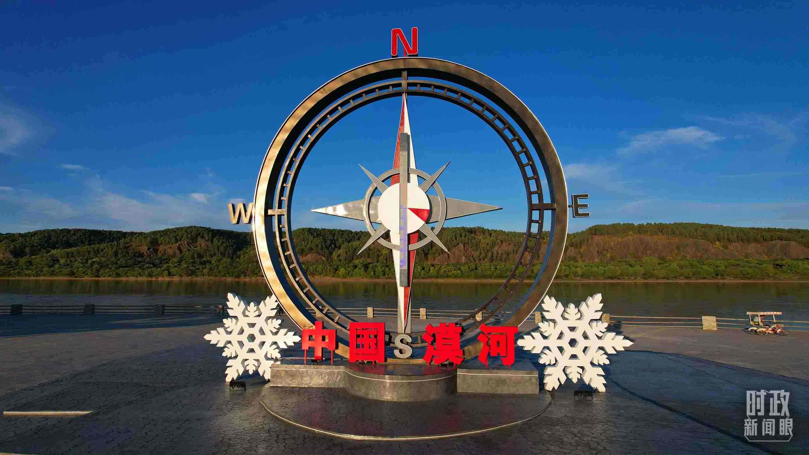 △指北針雕塑是北極村標志性建筑之一，其紅色指針指向正北方。上面的大型溫度計高12.22米，象征北極村位于東經(jīng)122°20′。（總臺央視記者范凱拍攝）