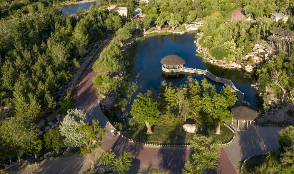 坐落在寧夏銀川市賀蘭山腳下的賀蘭山運動休閑公園（2021年5月27日攝，無人機(jī)照片）。這里曾是一片砂石采礦塌陷區(qū)，當(dāng)?shù)赝ㄟ^植被景觀再造、水系建設(shè)、現(xiàn)代管網(wǎng)鋪建等手段，重新利用廢石、廢坑及各類廢棄建筑材料，把這里變成一座免費開放的主題公園。新華社記者 馮開華 攝