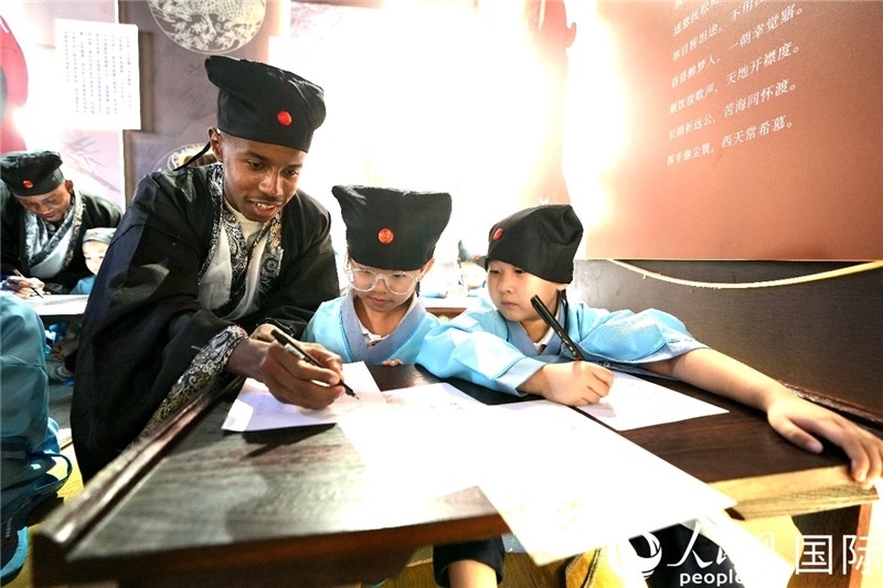 圖為選手與同學(xué)們一起寫書法。人民網(wǎng) 盧鵬宇攝