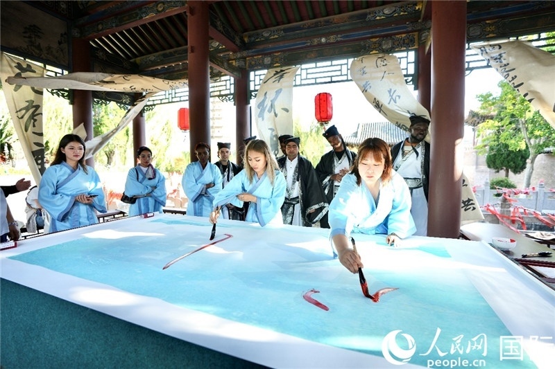 選手們提筆書寫“家園”二字。人民網(wǎng) 盧鵬宇攝