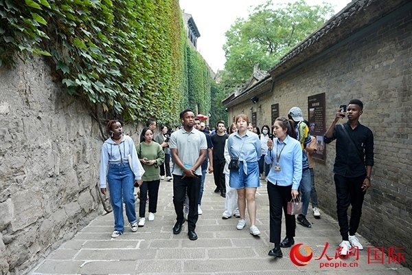 選手們認(rèn)真聆聽導(dǎo)游講解。人民網(wǎng) 盧鵬宇攝