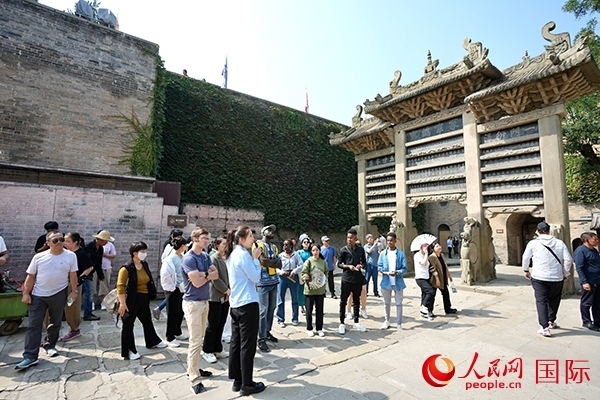 選手們認(rèn)真聆聽導(dǎo)游講解。人民網(wǎng) 盧鵬宇攝