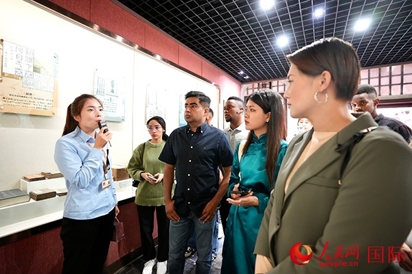 選手們認(rèn)真聆聽導(dǎo)游講解。人民網(wǎng) 盧鵬宇攝