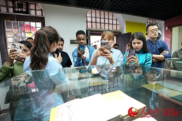 選手們認(rèn)真聆聽導(dǎo)游講解。人民網(wǎng) 盧鵬宇攝