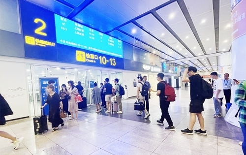 在快速進(jìn)站廳前排隊(duì)等待檢票的旅客。人民網(wǎng)記者 喬雪峰攝