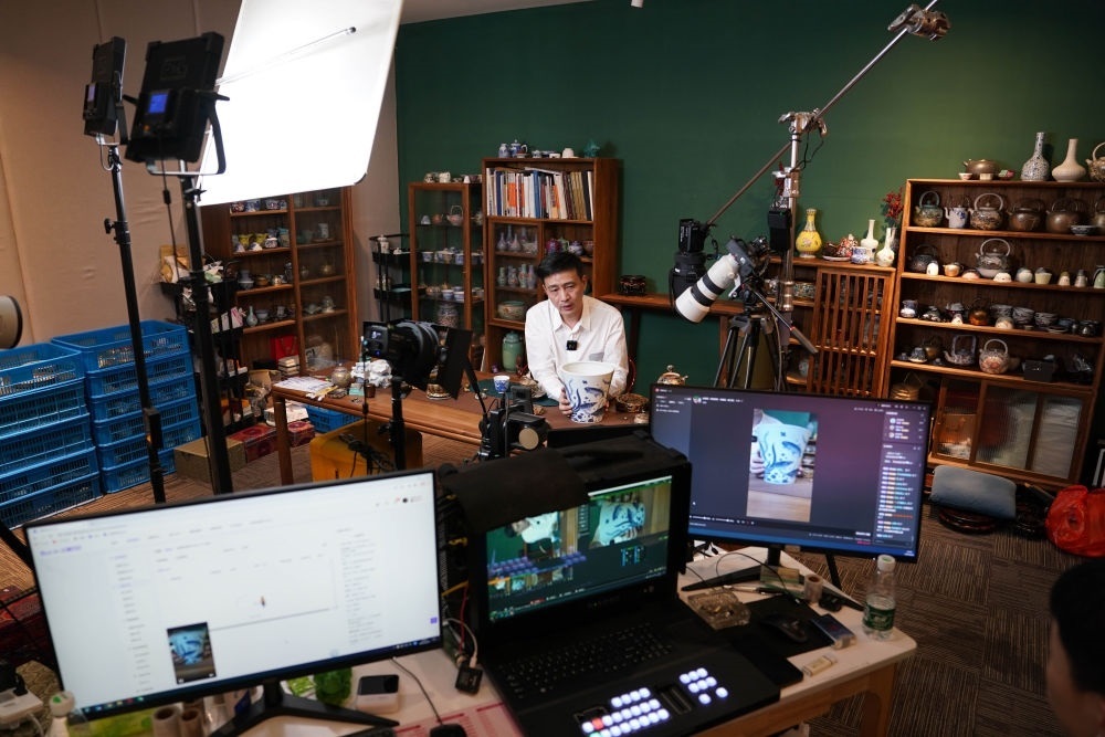 ↑在景德鎮(zhèn)，工作人員通過(guò)網(wǎng)絡(luò)直播推介陶瓷產(chǎn)品（2023年2月22日攝）。