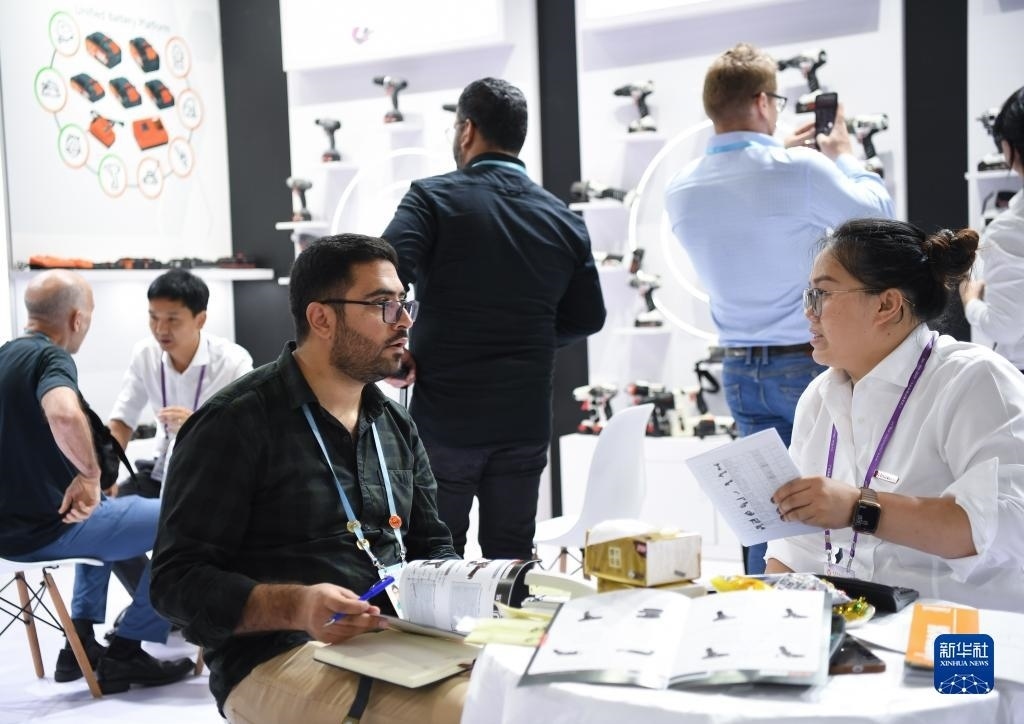 10月15日，在一家電動(dòng)工具展臺(tái)，外國采購商在洽談業(yè)務(wù)。新華社記者 鄧華 攝