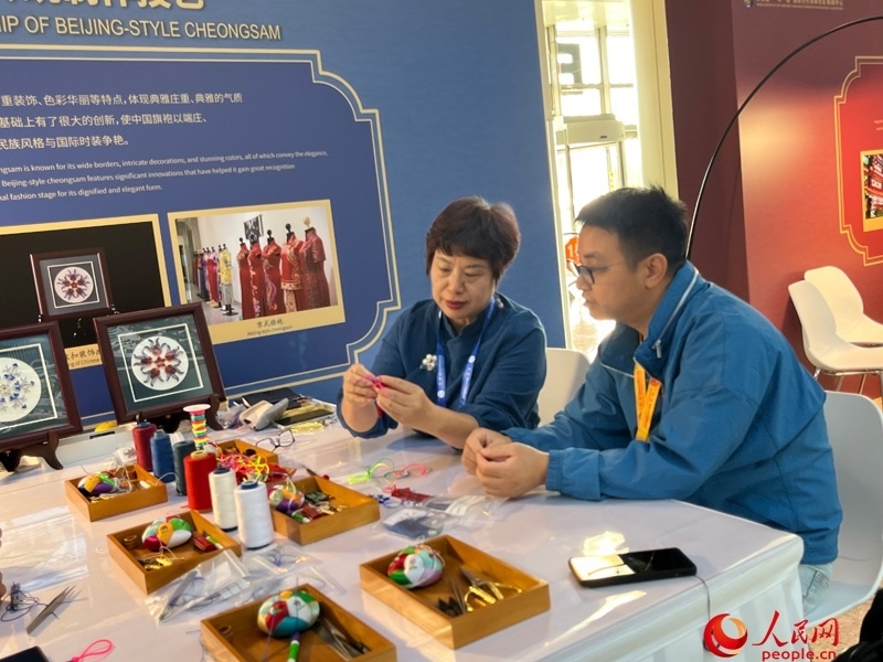 記者在新聞中心非遺傳承人展區(qū)進(jìn)行體驗(yàn)。人民網(wǎng)記者 杜燕飛攝