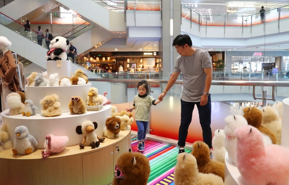 2023年11月2日，顧客在溫暖駝品牌專(zhuān)柜內(nèi)選購(gòu)。連續(xù)六年參加進(jìn)博會(huì)的秘魯羊駝制品品牌溫暖駝在上海市中心商場(chǎng)開(kāi)設(shè)了專(zhuān)柜。新華社記者 方喆 攝