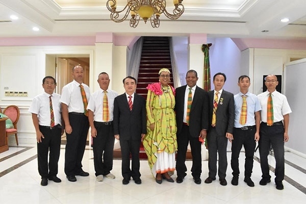 多米尼克總統(tǒng)伯頓和駐多米尼克大使林先江與中國(guó)農(nóng)業(yè)技術(shù)專家組合影。中國(guó)駐多米尼克大使館供圖