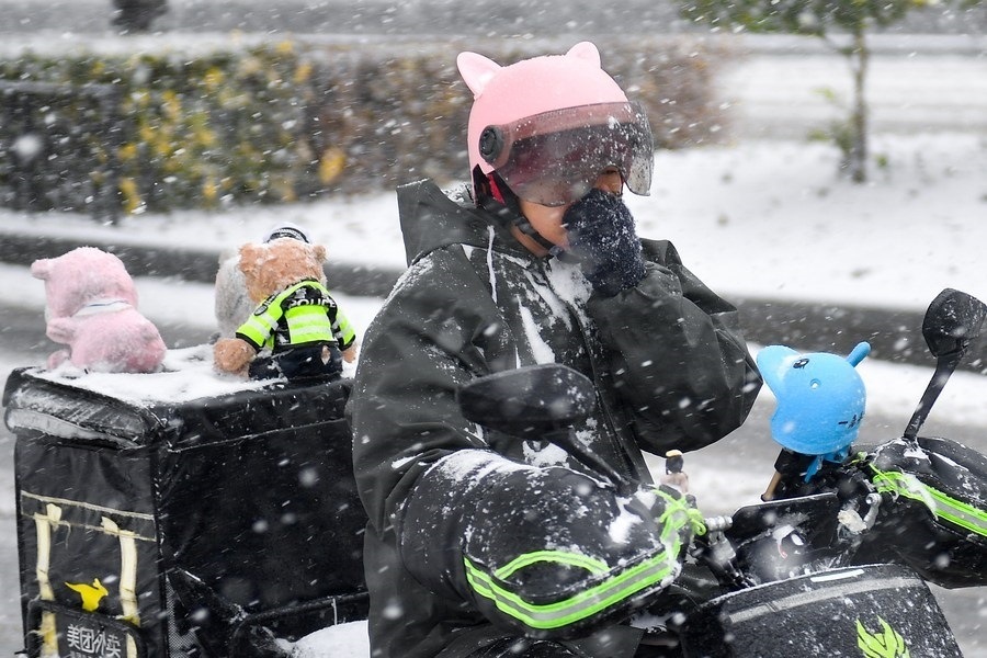 11月6日，在長(zhǎng)春市街頭，一名外賣員在雪中騎行。新華社記者 許暢 攝