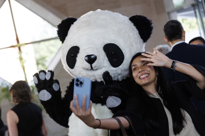2022年8月24日，在美國華盛頓中國駐美國大使館，來賓與大熊貓玩偶合影。