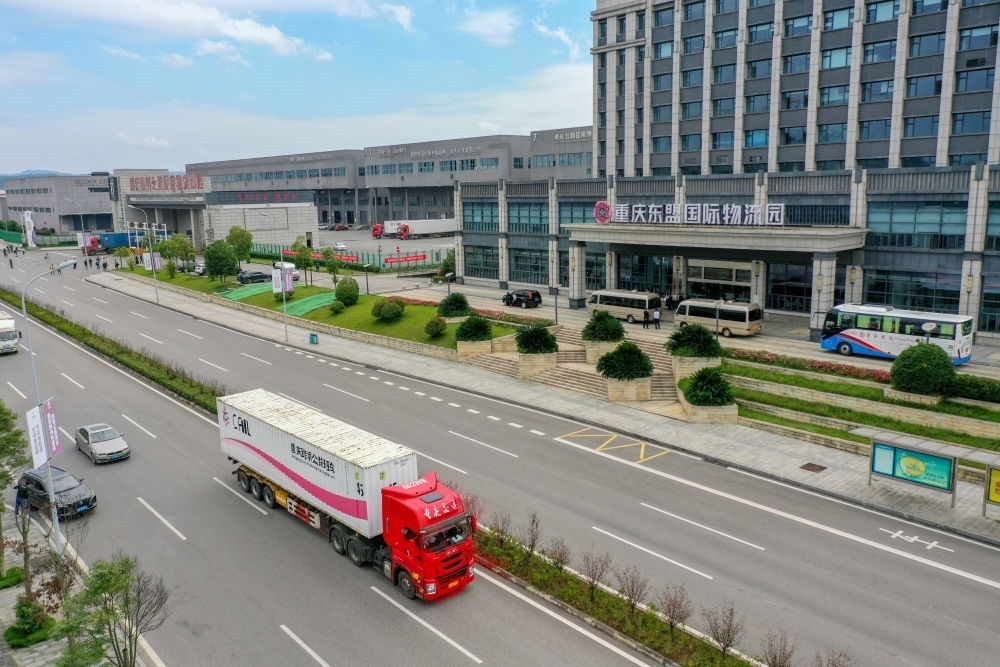 2023年10月11日，滿載筆記本電腦配件、發(fā)電機(jī)組件等產(chǎn)品的西部陸海新通道跨境公路班車從重慶南彭公路保稅物流中心駛出，將途經(jīng)廣西憑祥，直達(dá)越南（無人機(jī)照片）。新華社記者 黃偉 攝