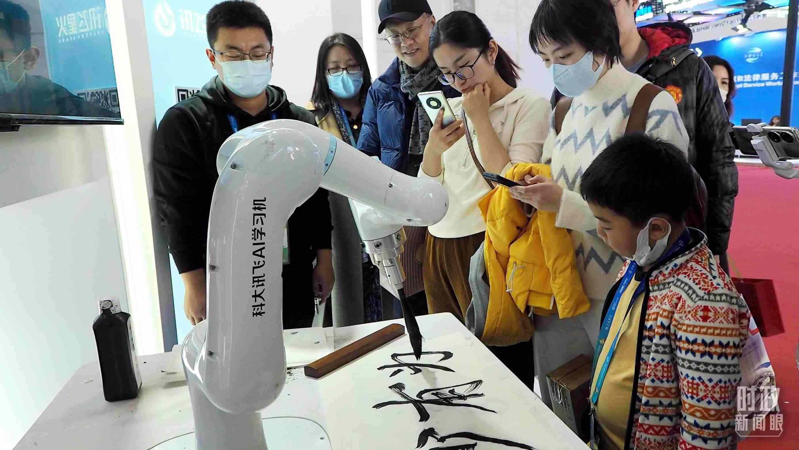 △觀眾在首屆鏈博會(huì)上體驗(yàn)AI書法機(jī)器人。