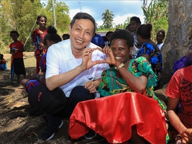 2023年12月18日，中國(guó)駐瓦努阿圖大使李名剛和前來(lái)觀看瓦努阿圖公路項(xiàng)目二期馬勒庫(kù)拉段移交儀式的當(dāng)?shù)鼐用窈嫌?。人民網(wǎng) 賀吉攝