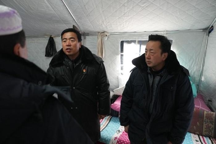 2023年12月22日，積石山縣大河家鎮(zhèn)大河村黨支部書記馬成忠（右二）在帳篷里和受災(zāi)群眾交流。新華社記者 陳斌 攝