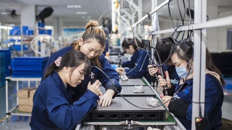 在新亞勝光電的產(chǎn)品線上，工人正進(jìn)行產(chǎn)品組建和安裝布線。受訪者供圖