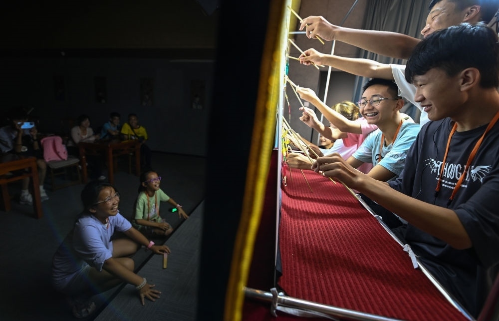 2023年8月8日，進(jìn)行暑期研學(xué)的學(xué)生在位于陜西省西安市的中國(guó)秦腔藝術(shù)博物館體驗(yàn)皮影戲演出。新華社記者 鄒競(jìng)一 攝