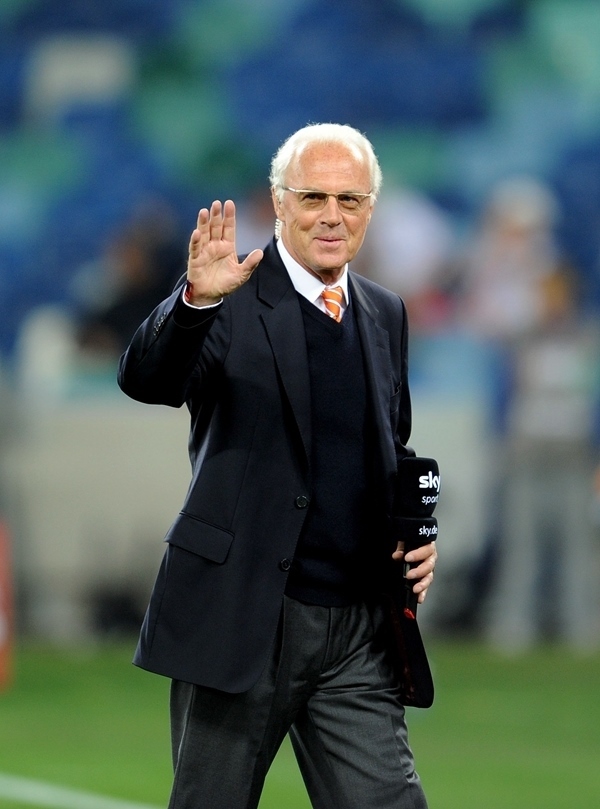 這是2010年7月7日，在南非德班舉行的2010年足球世界杯德國隊對陣西班牙隊的半決賽前，貝肯鮑爾接受電視臺采訪時和友人打招呼。新華社記者 王毓國 攝