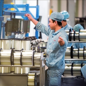 在位于武漢的長(zhǎng)飛光纖光纜股份有限公司光纖生產(chǎn)車間內(nèi)，工作人員對(duì)光纖進(jìn)行檢測(cè)（資料圖片）。肖藝九攝/本刊