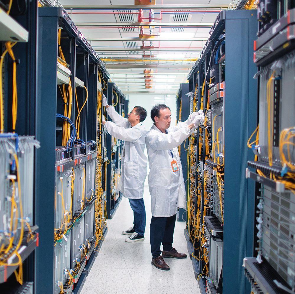 在位于武漢中國(guó)光谷的光電器件研發(fā)制造商——武漢光迅科技股份有限公司生產(chǎn)車間內(nèi)，技術(shù)人員在光模塊生產(chǎn)線作業(yè)（2023年4月11日攝）。程敏攝/本刊