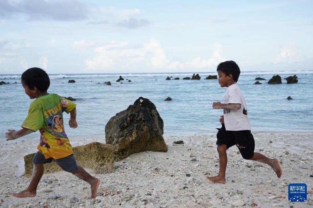 1月20日，兒童在瑙魯海邊嬉戲。新華社記者 王申 攝